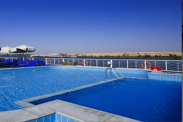 A swimming pool with blue tiles, a metal railing, and a desert landscape in the background. - JAZ Crown Jubilee Nile Cruise - Thursday VIA Luxor 7 & 4nts - Monday VIA Aswan 3nts (Luxor)