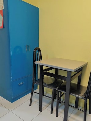 Ein Zimmer mit einem blauen Schrank, einem Tisch und zwei Stühlen.