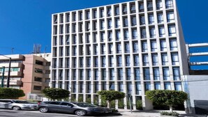 A modern building with a grid of windows, a flat roof, and a few trees in front. - Be Mate Condesa Hipodromo (Mexico City)