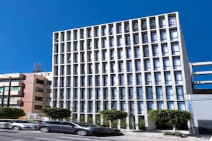 A modern building with a grid of windows, a flat roof, and a few trees in front. - Be Mate Condesa Hipodromo (Mexico City)