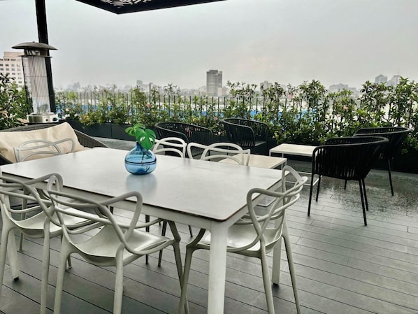 An outdoor seating area with a table and chairs, a decorative bowl, and a view of the cityscape. - Be Mate Condesa Hipodromo (Mexico City)