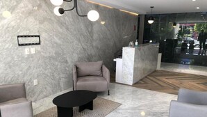 A modern lobby with a marble floor, a reception desk, and seating areas. - Be Mate Condesa Hipodromo (Mexico City)