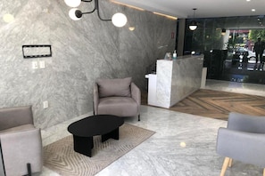 A modern lobby with a marble floor, a reception desk, and seating areas. - Be Mate Condesa Hipodromo (Mexico City)