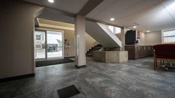 A spacious interior with a staircase, a kitchen area, and a seating area.
