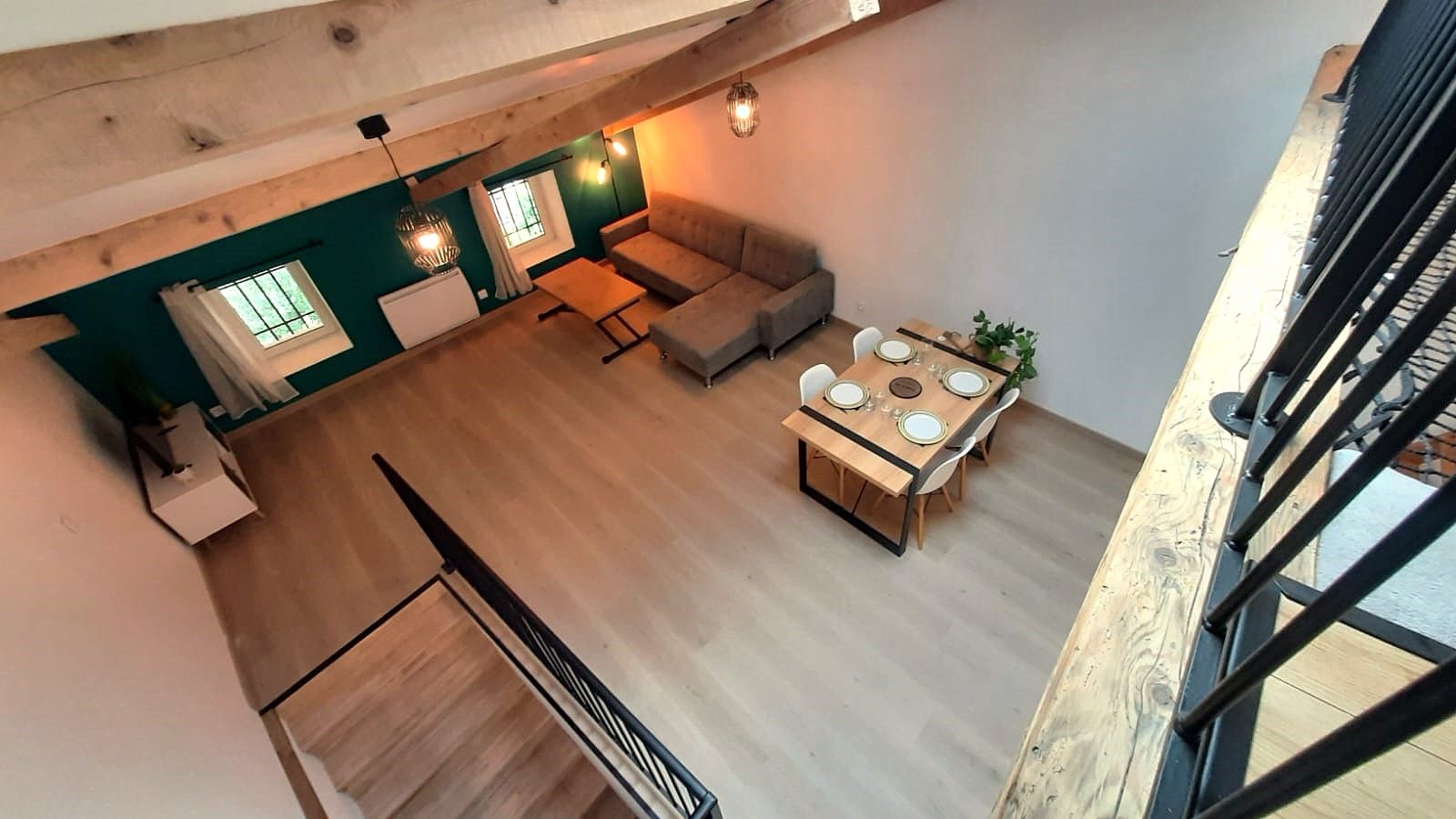 Un espacio habitable estilo loft con comedor, sofá y escalera.
