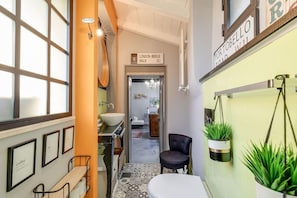 Un couloir étroit avec un lavabo, une chaise et un panneau indiquant « LONDON BRIDGE WALK SE1 ».