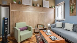 Een woonkamer met een bank, fauteuil, houten salontafel en een radio.