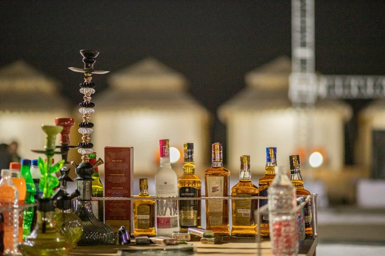 Un espace bar avec différentes bouteilles et un narguilé.