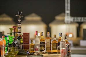 Un espace bar avec différentes bouteilles et un narguilé.