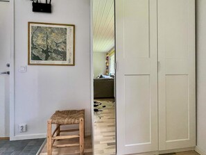 A room with a wooden chair, a framed map on the wall, and a wardrobe. - 6 Person Holiday Home in Gunnebo (Gunnebo)