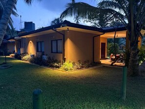 A modern building with a flat roof, a covered outdoor area, and a well-maintained lawn. - Don Cyril's Nature Bungalow (Galle)
