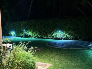 A well-maintained garden with a circular paved area and illuminated pathways. - Don Cyril's Nature Bungalow (Galle)