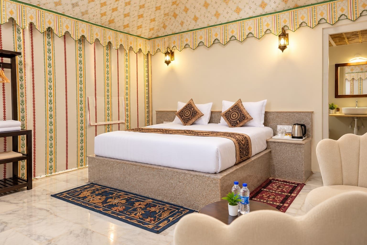 A hotel room with a large bed, a nightstand, a sofa, a coffee table, and a bathroom visible through an open door.