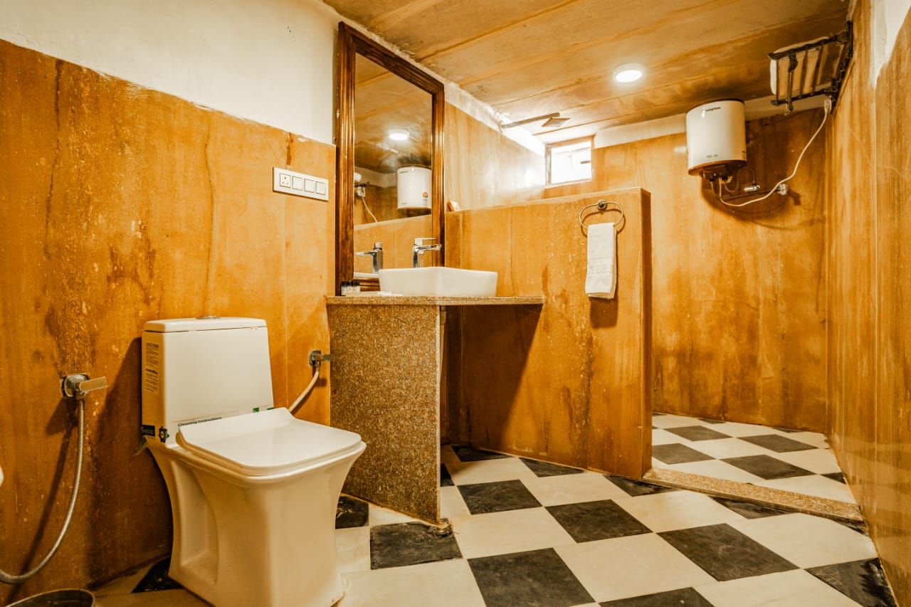 A bathroom with a toilet, sink, and mirror.