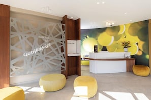 A reception area with a modern design, including a reception desk, a decorative partition, and seating areas. - Auberge De Clochemerle (Vaux-en-Beaujolais)