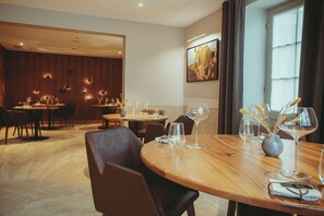 A hotel dining area with round tables, chairs, and wine glasses. - Auberge De Clochemerle (Vaux-en-Beaujolais)
