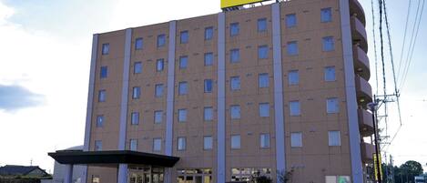 A hotel with a yellow sign reading 'Smile Hotel' on the top.