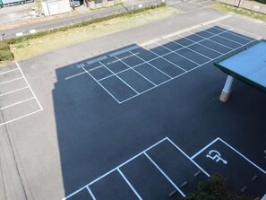 Un parking avec des emplacements délimités, dont un emplacement réservé aux personnes handicapées.