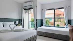 Habitación de hotel con cama, ventana con cortinas, equipo de aire acondicionado y vista al exterior.