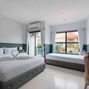 A hotel room with a bed, a window with curtains, an air conditioning unit, and a view of the outside. - Chanita Hotel Chumphon (Chumphon)