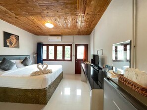 A hotel room with a bed, a desk, a television, and a large mirror. - Mook Boonchu Hotel (Ko Mook)