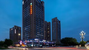 Um edifício alto com vários andares, grandes janelas e uma placa de destaque na lateral.
