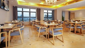Uma sala de jantar moderna com mesas e cadeiras redondas, amplas janelas com vista para a cidade e um lustre.