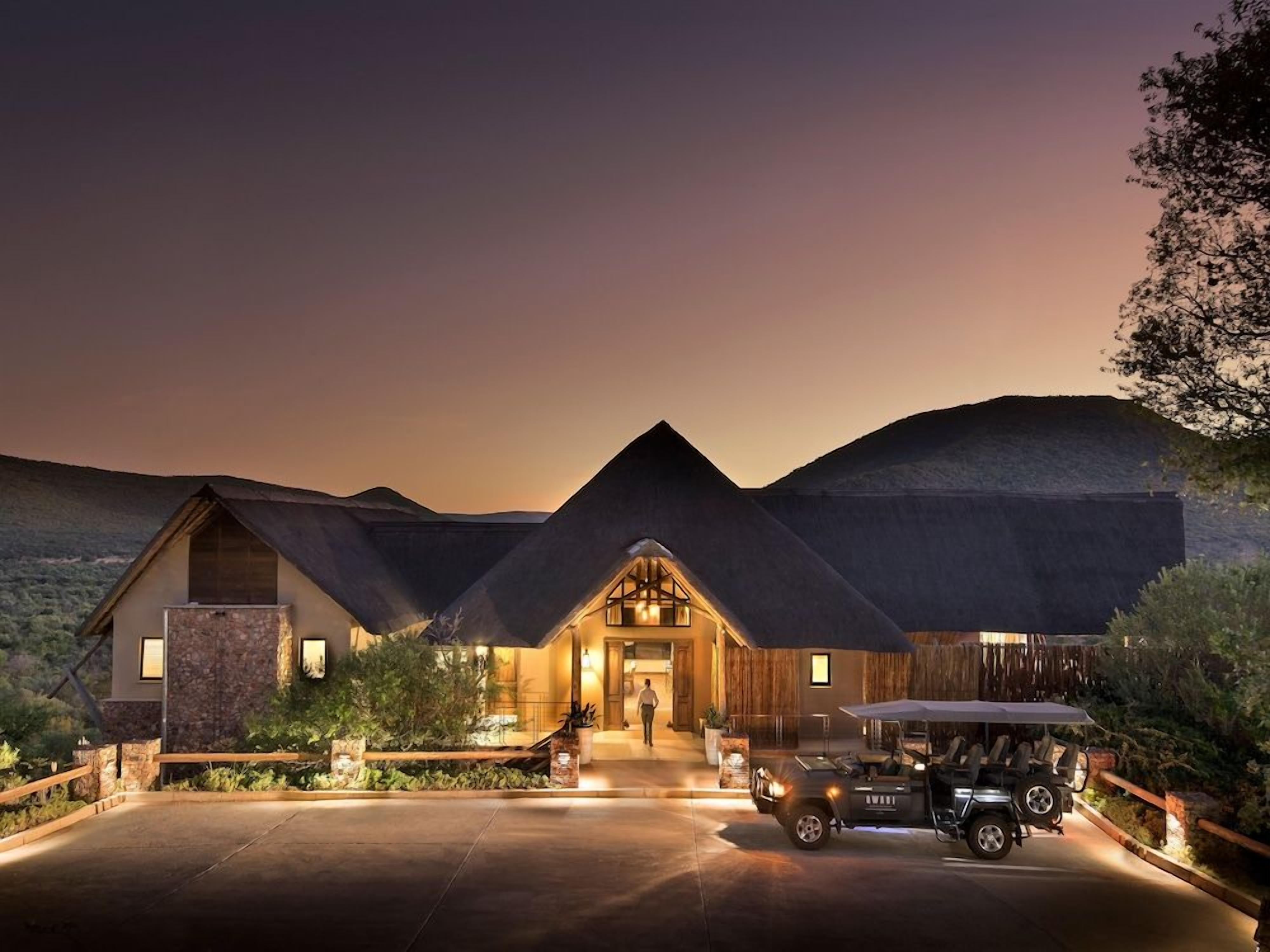 A large, modern building with a prominent entrance, a driveway, and a golf cart parked in front.