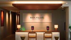 A reception desk with a sign reading 'POOL VILLA KOURISIMA' and two chairs in front. - Loisir Terrace and Villas Kouri (Nakijin)