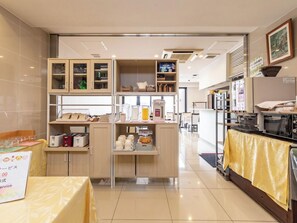 Une cuisine moderne dotée d’appareils électroménagers intégrés, d’un espace dédié à la préparation du café et d’un coin repas.