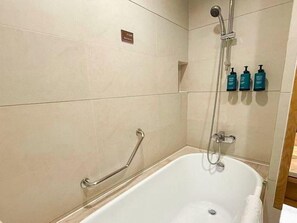 A bathroom with a bathtub, a shower, and a handrail. - Club Med Joyview Beijing Yanqing (Beijing)