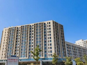 A multi-story building with a grid of windows and a flat roof. - West Mansion Hotel Beijing (Beijing)