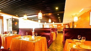 A restaurant with tables set for dining, featuring a warm color scheme and modern lighting fixtures. - West Mansion Hotel Beijing (Beijing)