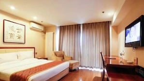 A hotel room with a bed, a desk, a chair, a TV, and a window with curtains. - West Mansion Hotel Beijing (Beijing)