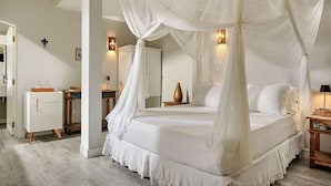 A bedroom with a four-poster bed, a nightstand, a mirror, and a wardrobe. - Mona Lisa Pousada (Jijoca de Jericoacoara)