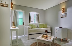 A compact living space with a white sofa, a small table, a white cabinet, and a radiator. - Mona Lisa Pousada (Jijoca de Jericoacoara)