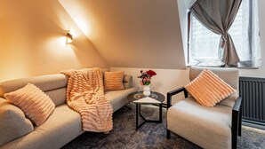 Una sala de estar acogedora con un sofá, un sillón y una mesita de centro.