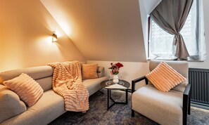 Ein gemütliches Wohnzimmer mit einer Couch, einem Sessel und einem Couchtisch.