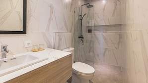 A modern bathroom with a marble sink, wooden vanity, a glass-enclosed shower, and a toilet. - Cypress Villa by Zuzu (Ungasan)