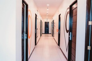 Un passadís amb portes a ambdós costats que condueix a una habitació fosca al final.