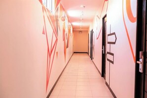 Un couloir doté d’un sol carrelé et de murs ornés de motifs géométriques.