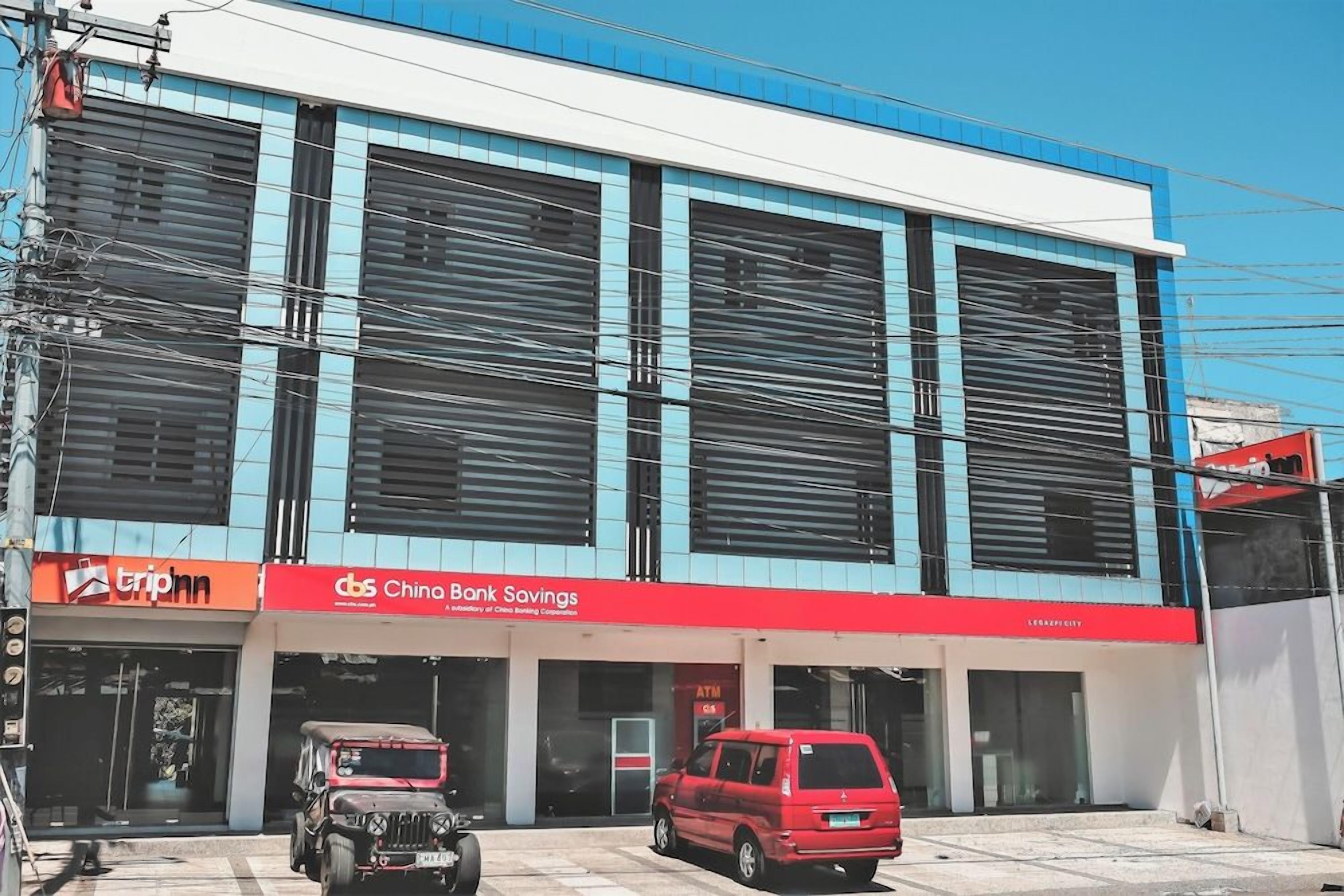 A commercial building with a blue and white facade, featuring storefronts for 'triphn' and 'Chino Bank Savings'.