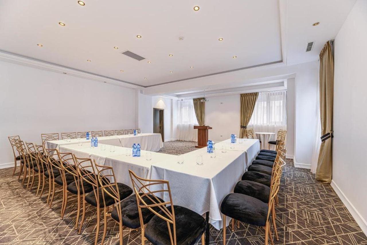 A conference room with a long table, chairs, and a podium.