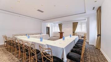 A conference room with a long table, chairs, and a podium.