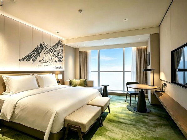 A hotel room with a large bed, a desk, a chair, and a view of the sky.