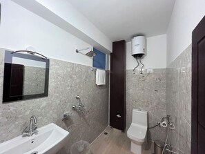 Ein Badezimmer mit Waschbecken, Toilette, Dusche und Handtuchhalter.