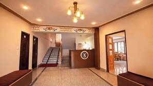 A hotel lobby with a reception desk, a staircase, and a reception area. - Ecotel Lachung (Chungthang)