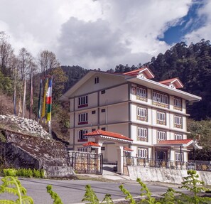 Un edifici de diversos pisos amb un estil arquitectònic tradicional, amb balcons i un teulat de teules vermelles.