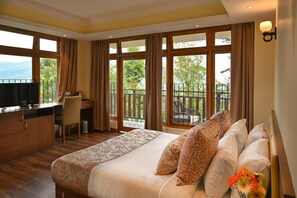 Une chambre d’hôtel dotée d’un grand lit, d’un bureau et d’un balcon offrant une vue sur l’extérieur.
