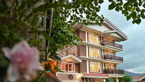 Monikerroksinen rakennus, jossa on parvekkeita, portaikko ja Yashshree Arbari Resort & Spa -kyltti.